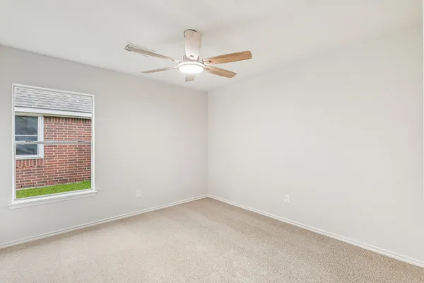 an empty room with closet and a ceiling fan
