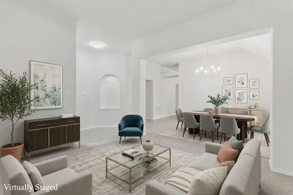 a living room with furniture a dining table and a potted plant