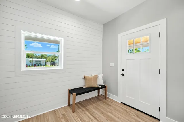 a hallway with wooden floor and a window