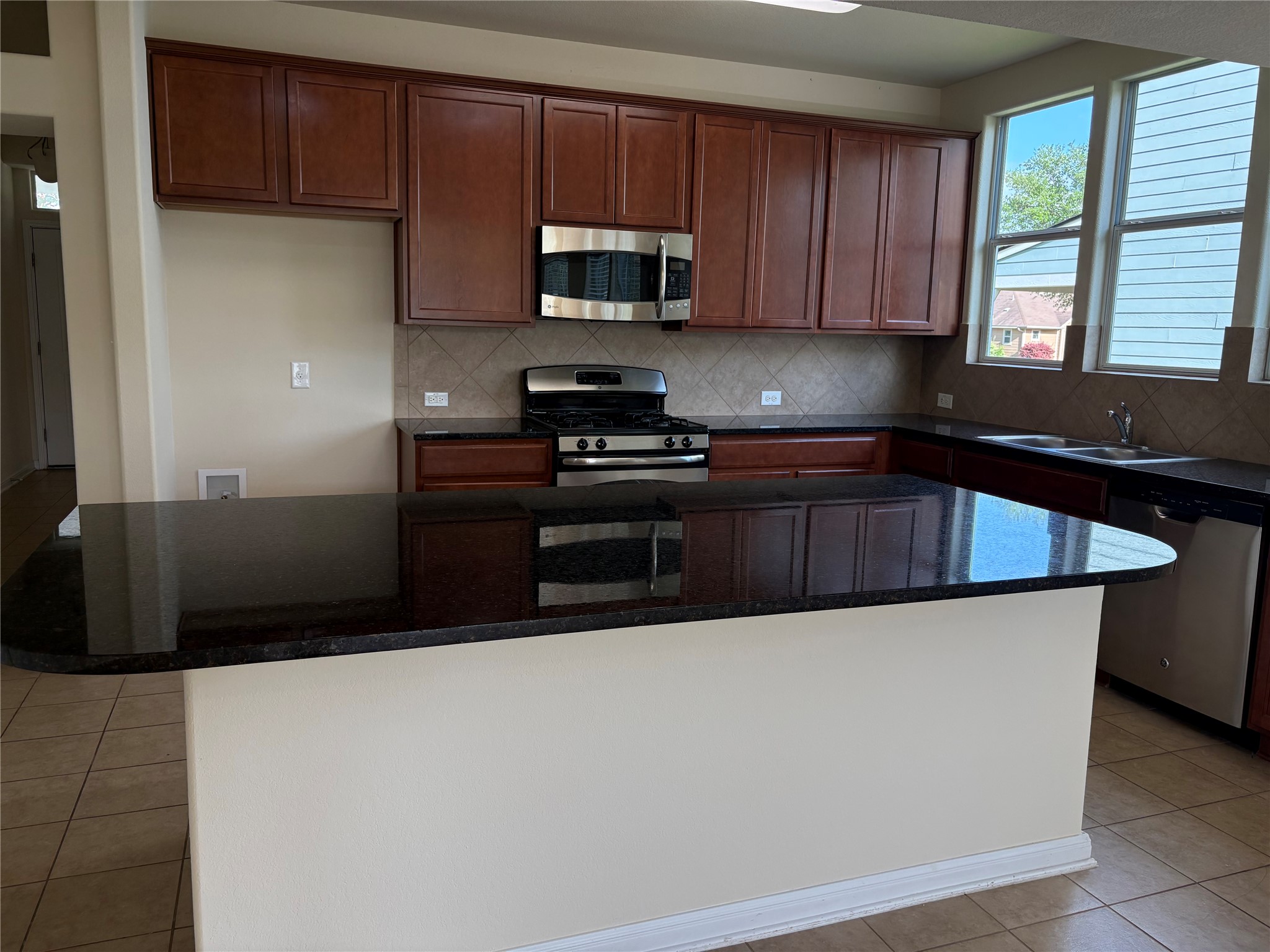 1076 Sanders Kyle, TX 78640 - Photo 11 of 40 dark stone countertops, tile backsplash, and tile flooring