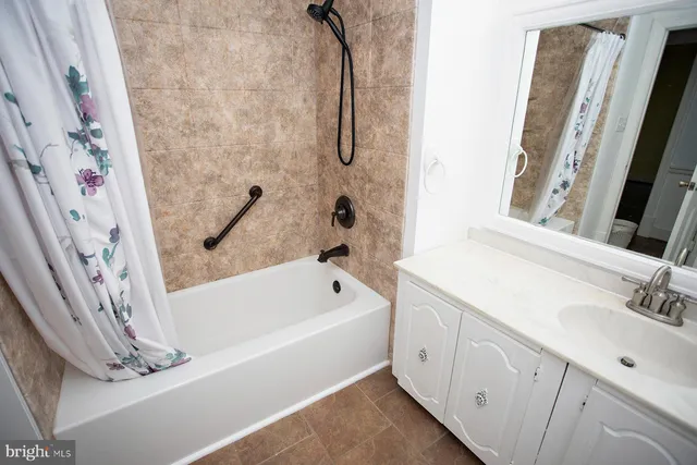 a bathroom with a tub sink a mirror and a shower