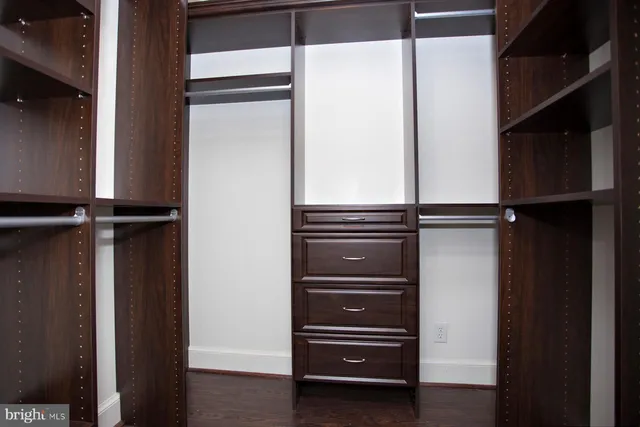 a view of walk in closet with wooden floor