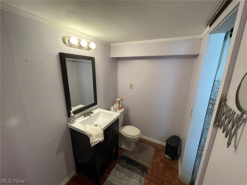 28634 Forest Road Willowick, OH 44095 - Photo 28 of 39 Bathroom featuring a dark wood-finish vanity with a white basin sink, a framed rectangular mirror, and a three-bulb vanity light fixture
