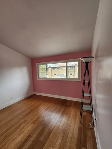 a view of an empty room window and wooden floor