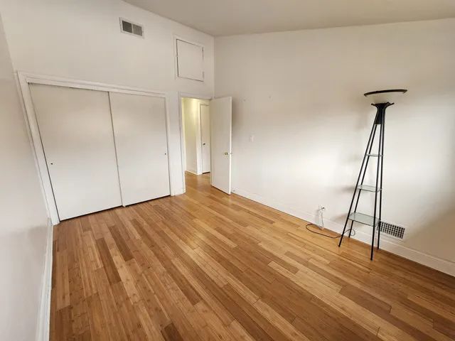a view of empty room with wooden floor
