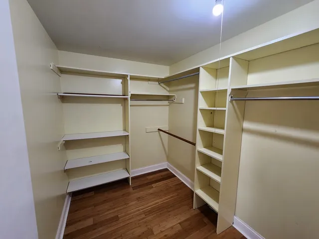 a view of walk in closet with empty racks