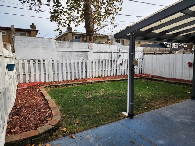 a view of a backyard with brick wall and potted plants