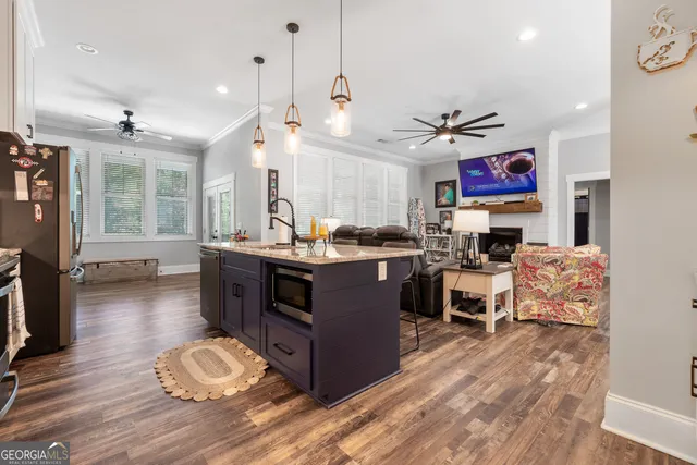 a kitchen with stainless steel appliances granite countertop a sink refrigerator and cabinets