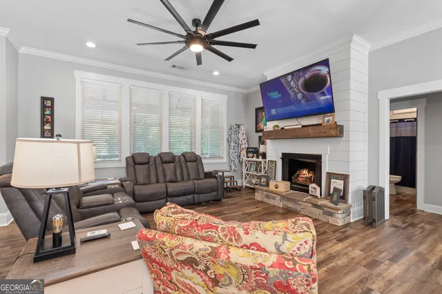 a living room with furniture a flat screen tv and a fireplace