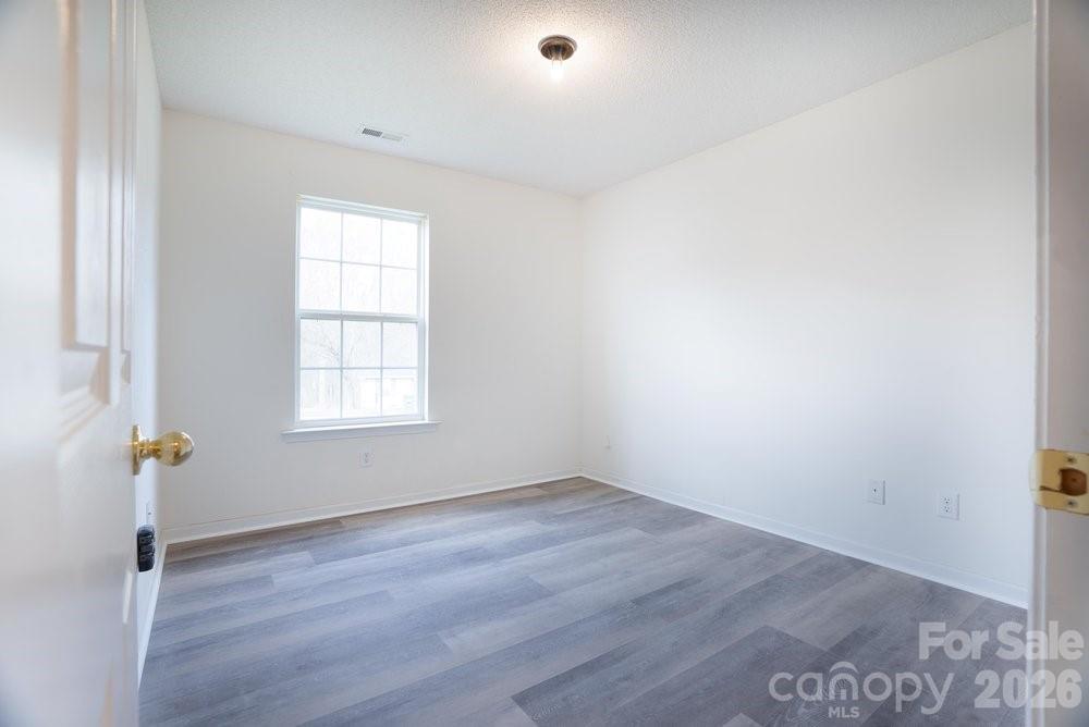122 Addison Place Troutman, NC 28166 - Photo 21 of 40 an empty room with wooden floor and windows