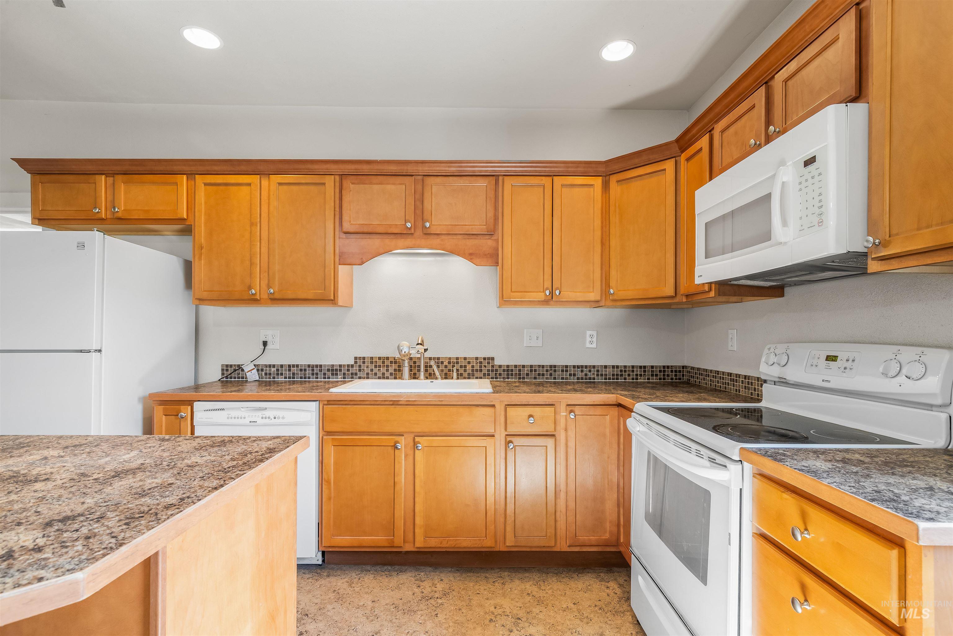 815 2nd Street Asotin, WA 99402 - Photo 12 of 50 Kitchen with white appliances, recessed lighting, and brown cabinetry