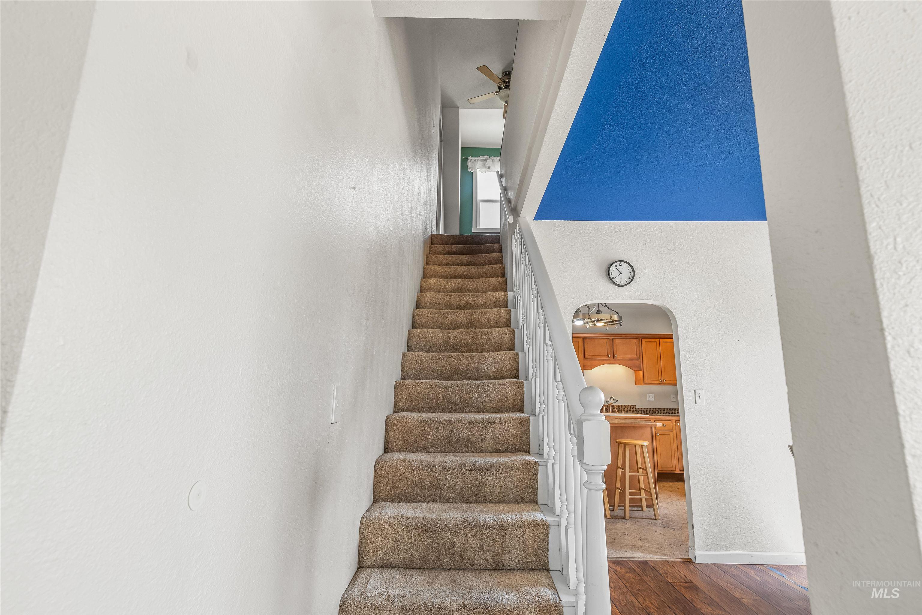 815 2nd Street Asotin, WA 99402 - Photo 19 of 50 Stairway featuring arched walkways, wood finished floors, ceiling fan, a towering ceiling, and a textured wall