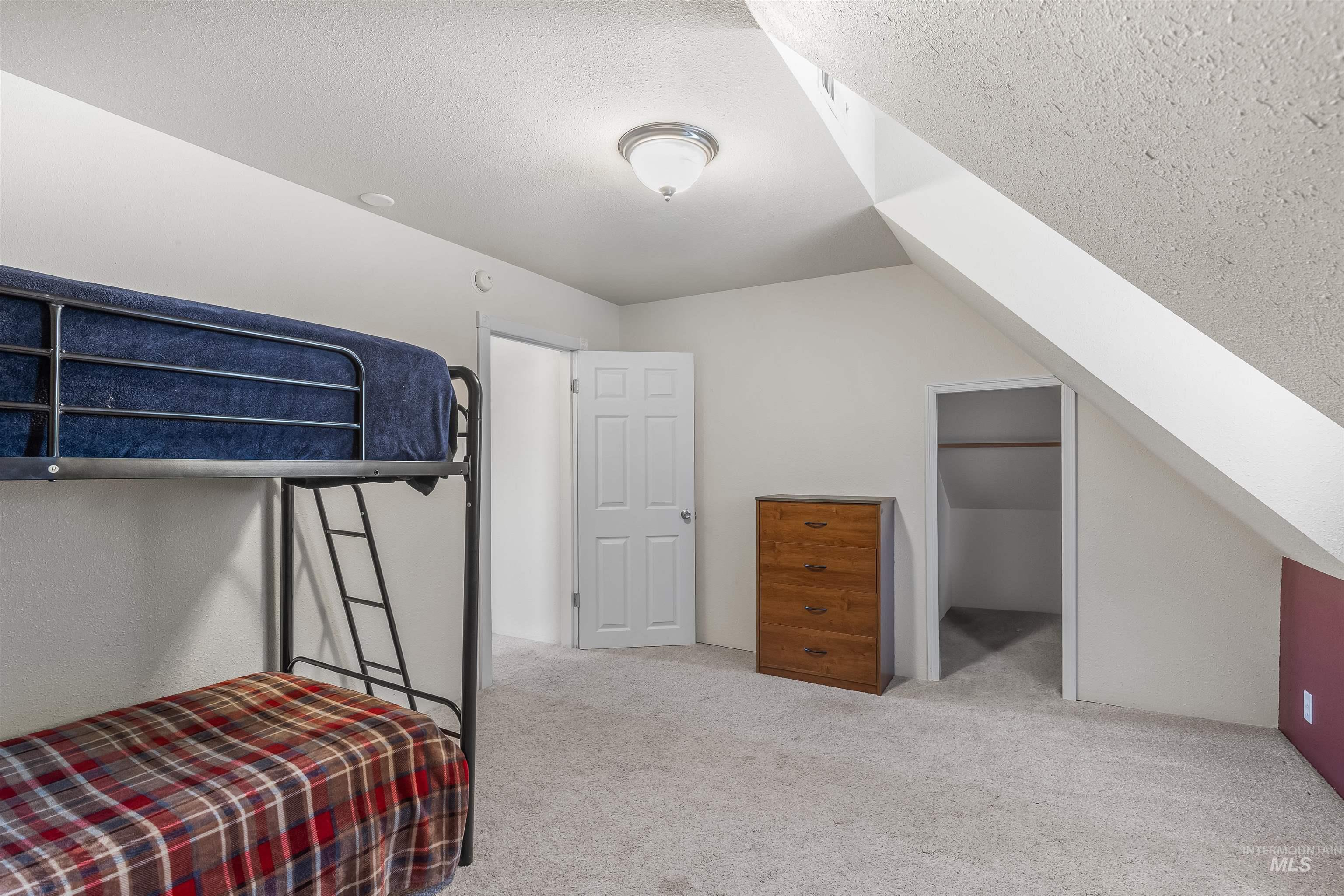 815 2nd Street Asotin, WA 99402 - Photo 29 of 50 Carpeted bedroom featuring a textured ceiling and vaulted ceiling