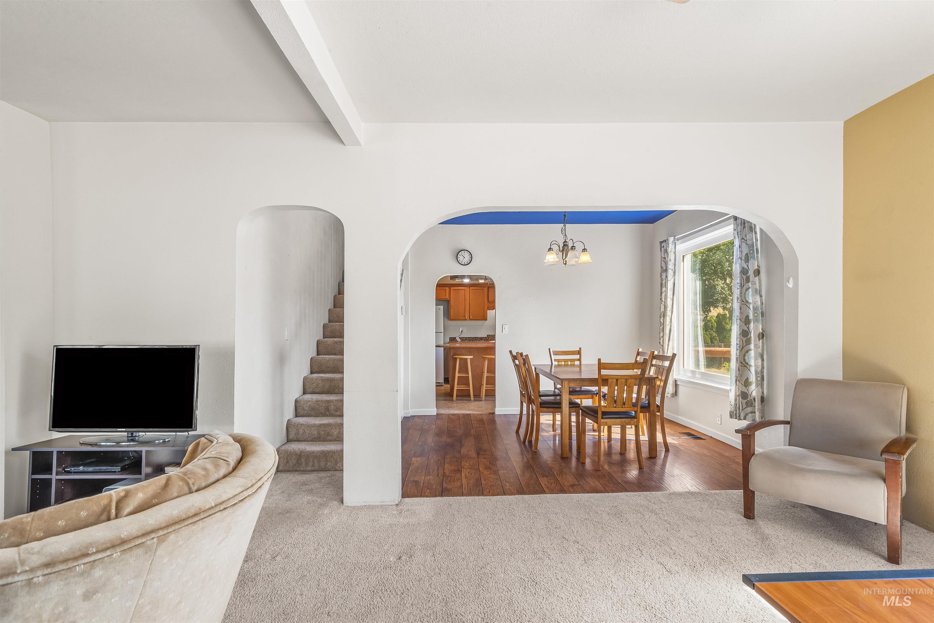 815 2nd Street Asotin, WA 99402 - Photo 7 of 50 Dining space featuring carpet, stairs, arched walkways, a chandelier, and beam ceiling
