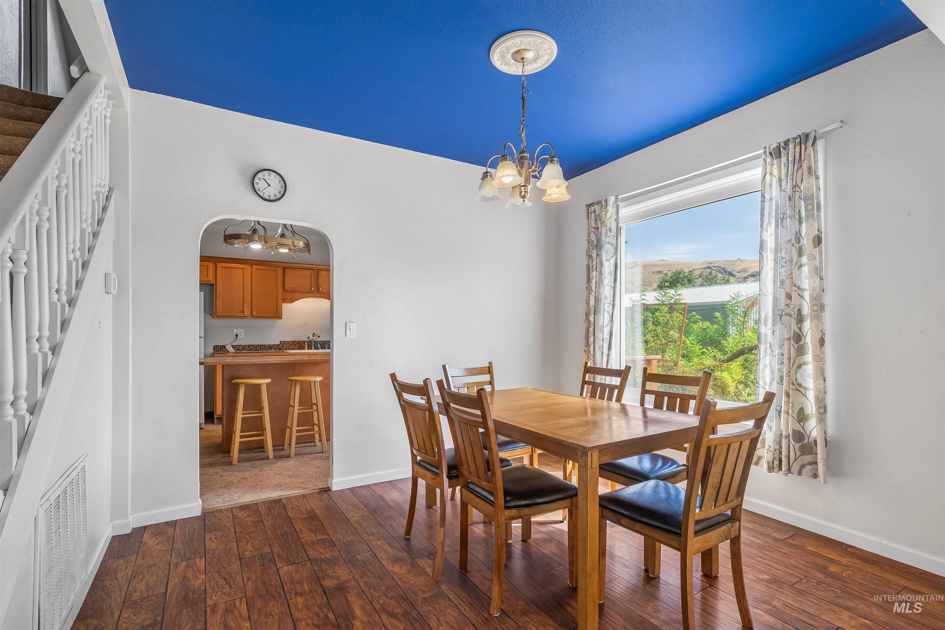 815 2nd Street Asotin, WA 99402 - Photo 9 of 50 Dining room with arched walkways, stairway, dark wood-style floors, and a chandelier