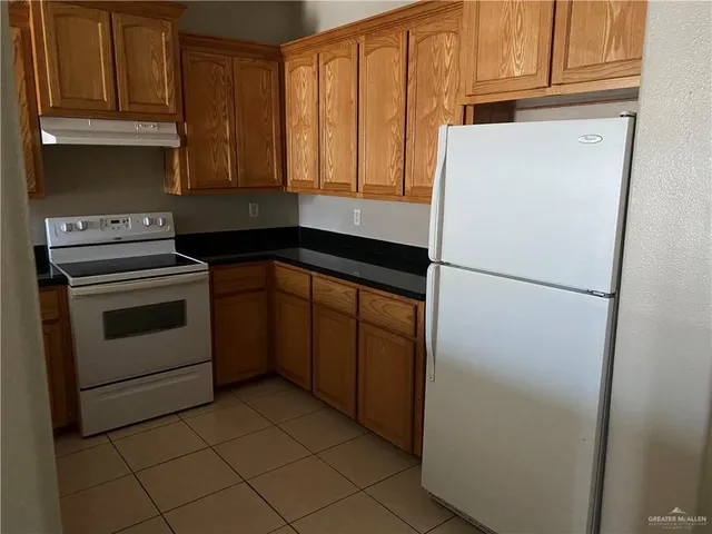 a kitchen with a refrigerator sink and cabinets