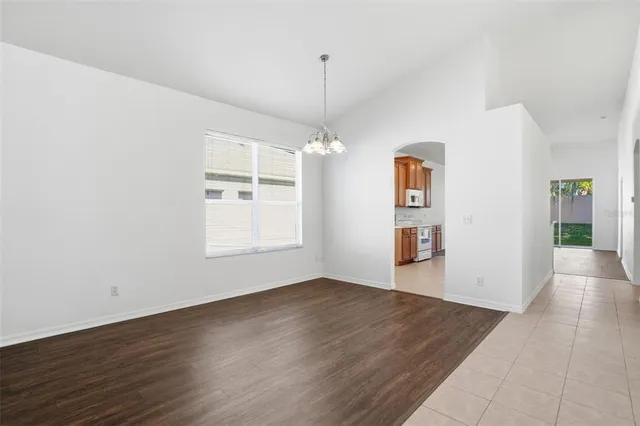 an empty room with wooden floor cabinet and windows
