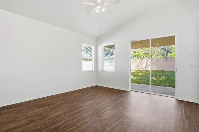a view of a livingroom with wooden floor and a large window