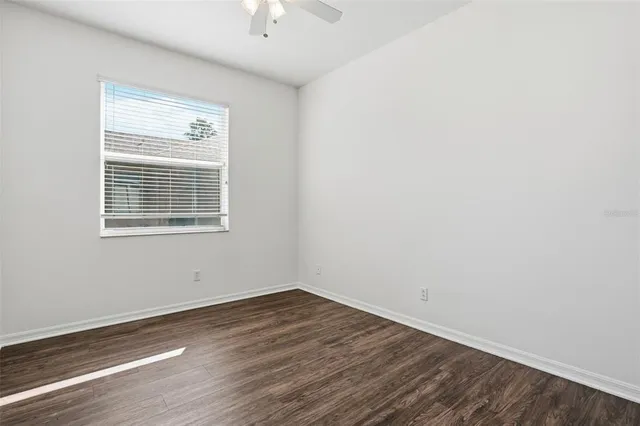 an empty room with wooden floor and a window