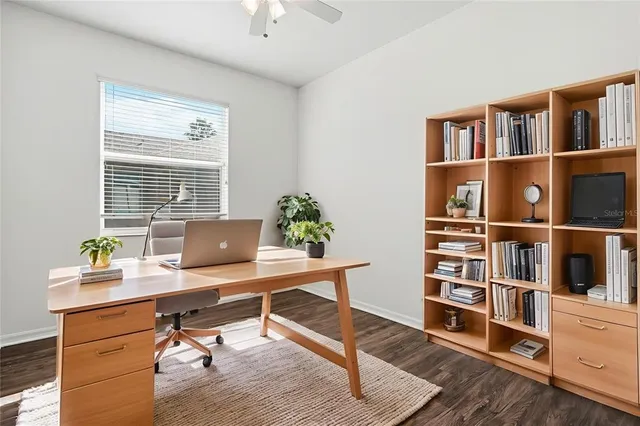 a view of a workspace with furniture and a bookshelf