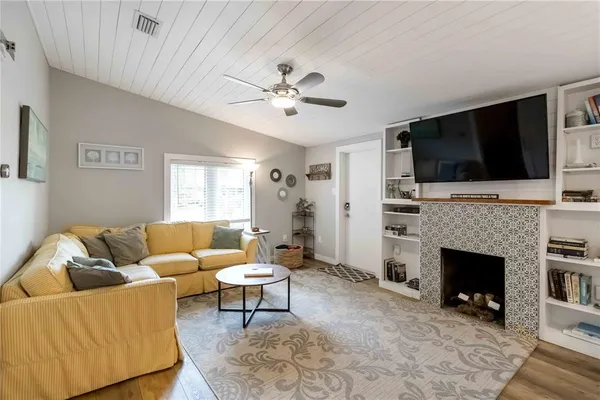 a living room with furniture a flat screen tv and a fireplace