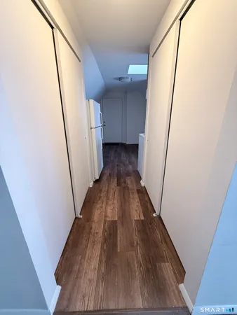 a view of a hallway with wooden floor