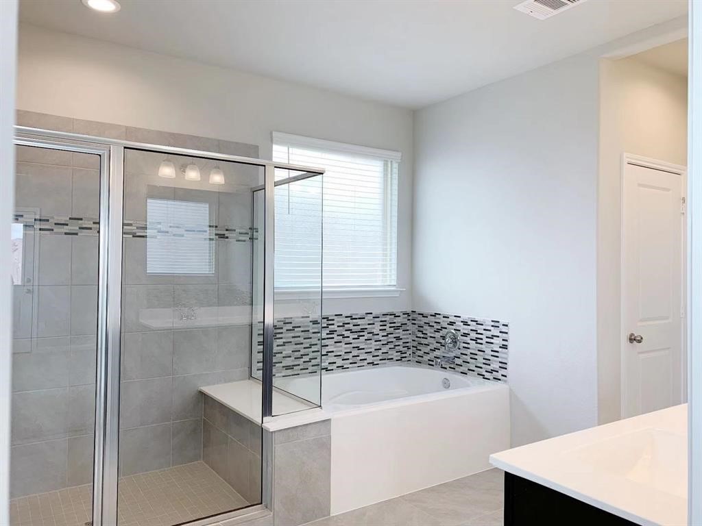 29026 Endeavor River Road Katy, TX 77494 - Photo 13 of 27 a bathroom with a bathtub and a shower