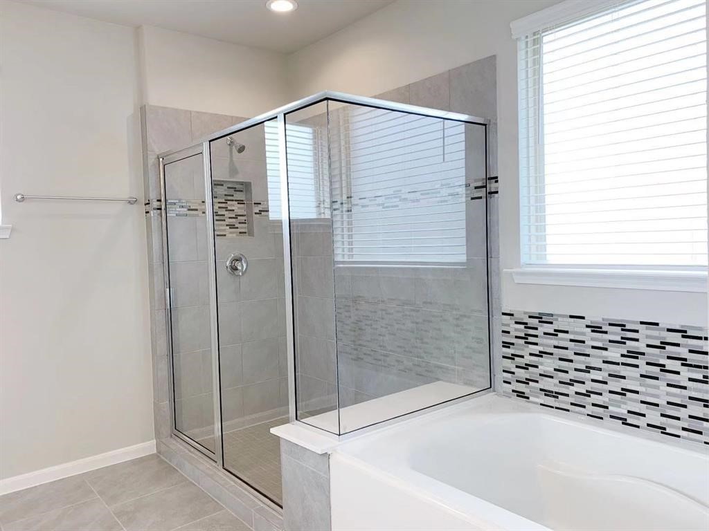 29026 Endeavor River Road Katy, TX 77494 - Photo 15 of 27 a bathroom with a bathtub and a shower