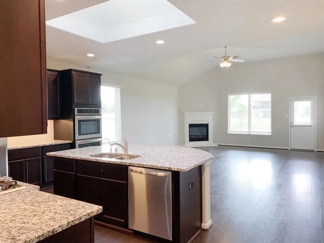 a kitchen with stainless steel appliances kitchen island granite countertop a stove and a refrigerator
