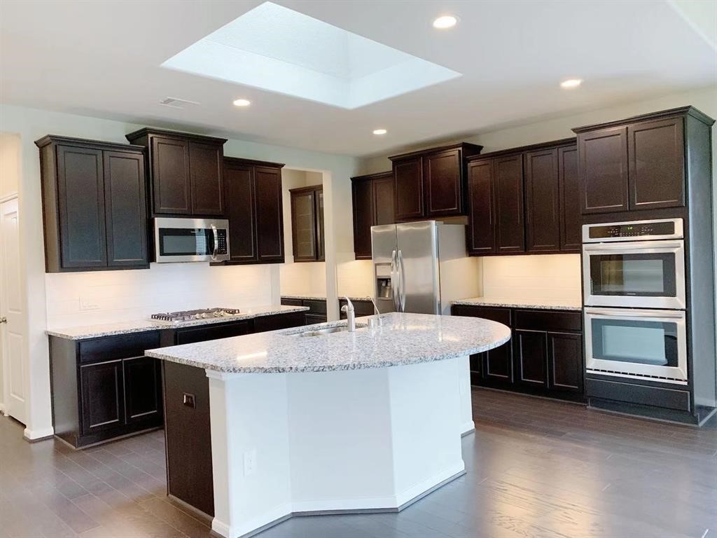 29026 Endeavor River Road Katy, TX 77494 - Photo 8 of 27 a kitchen with stainless steel appliances kitchen island granite countertop a stove and a refrigerator