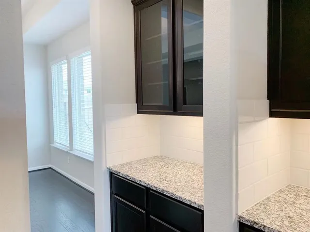 an empty room with wooden floor fireplace and windows