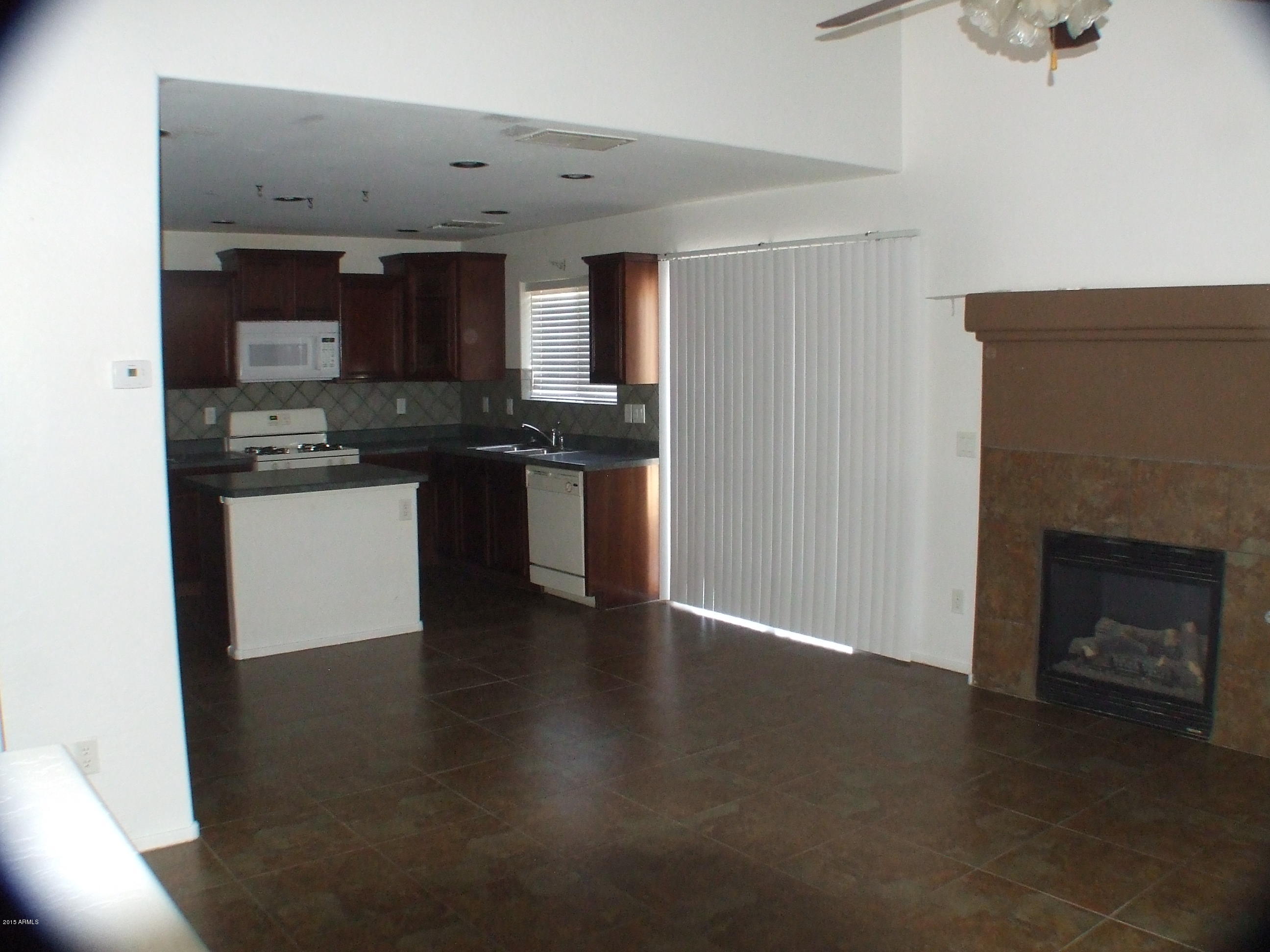718 West Spruell Avenue Coolidge, AZ 85128 - Photo 4 of 15 a kitchen with stainless steel appliances granite countertop a stove top oven a sink and a refrigerator