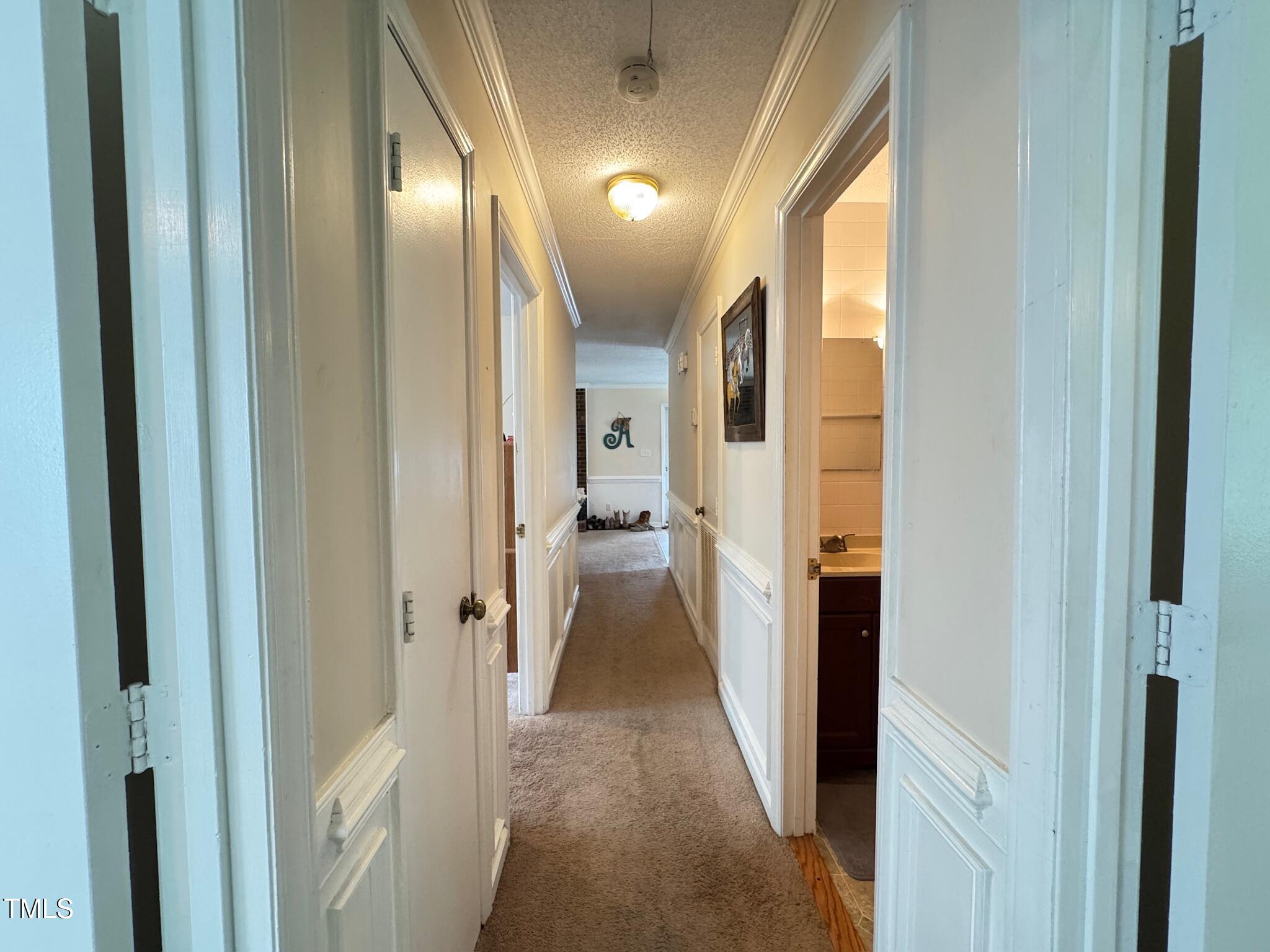 2229 Lizard Lick Road Zebulon, NC 27597 - Photo 21 of 57 a view of a hallway with wooden floor and a bathroom