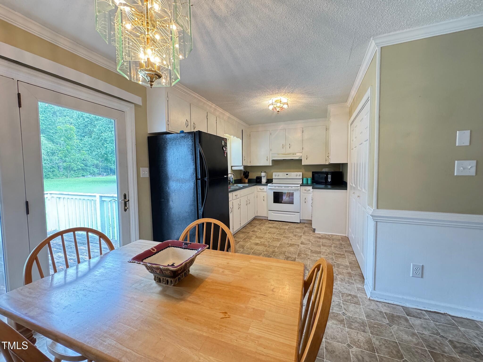 2229 Lizard Lick Road Zebulon, NC 27597 - Photo 24 of 57 a kitchen with stainless steel appliances granite countertop a refrigerator a stove a sink dishwasher with a dining table and chairs
