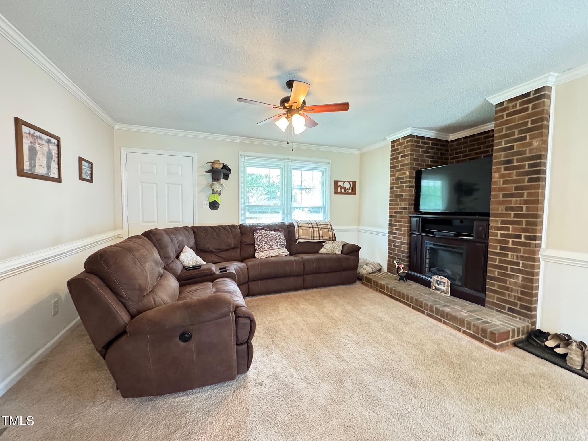2229 Lizard Lick Road Zebulon, NC 27597 - Photo 26 of 57 a living room with furniture a flat screen tv and a fireplace