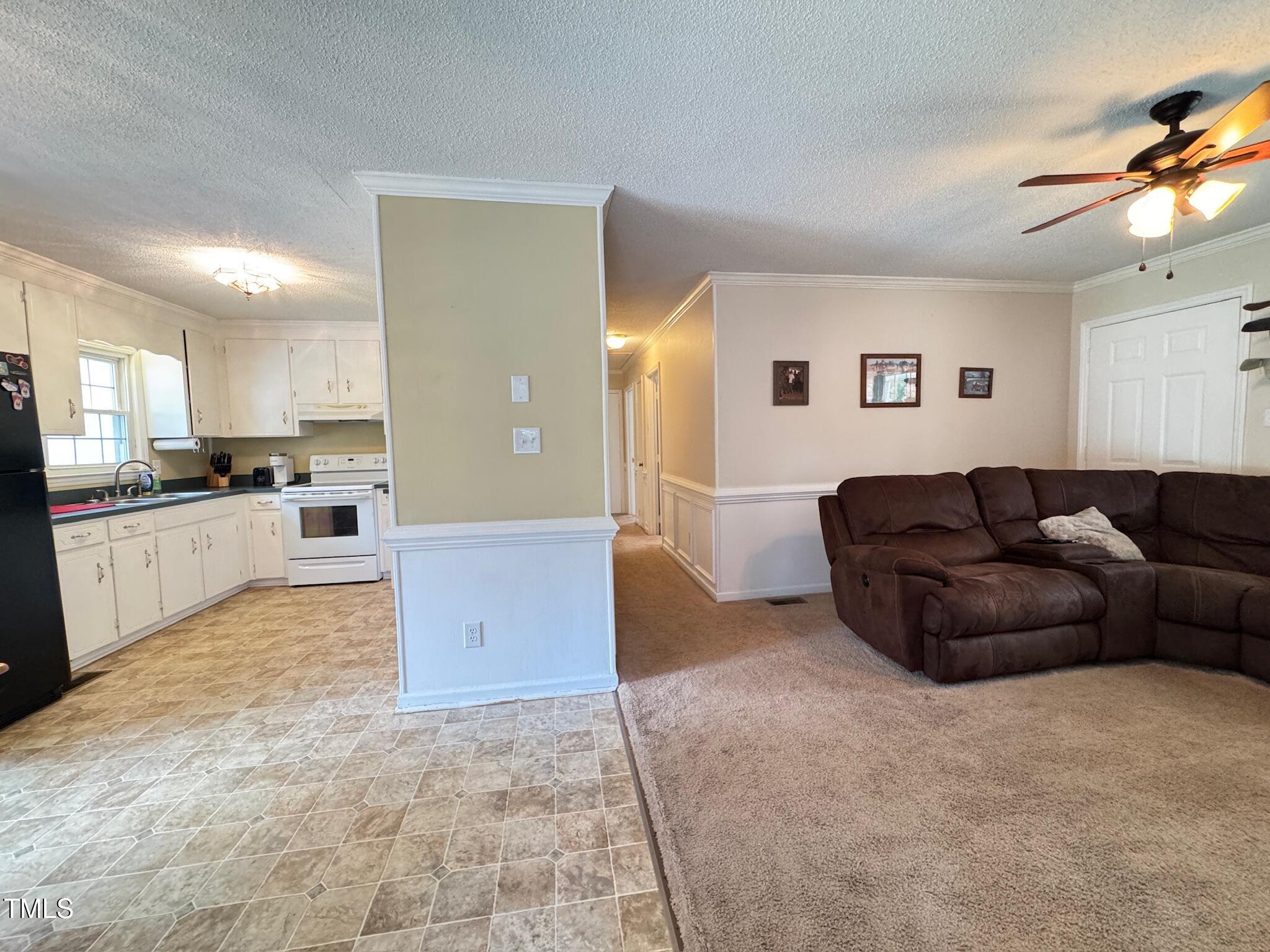 2229 Lizard Lick Road Zebulon, NC 27597 - Photo 40 of 57 a living room with a couch and a dining table with kitchen view