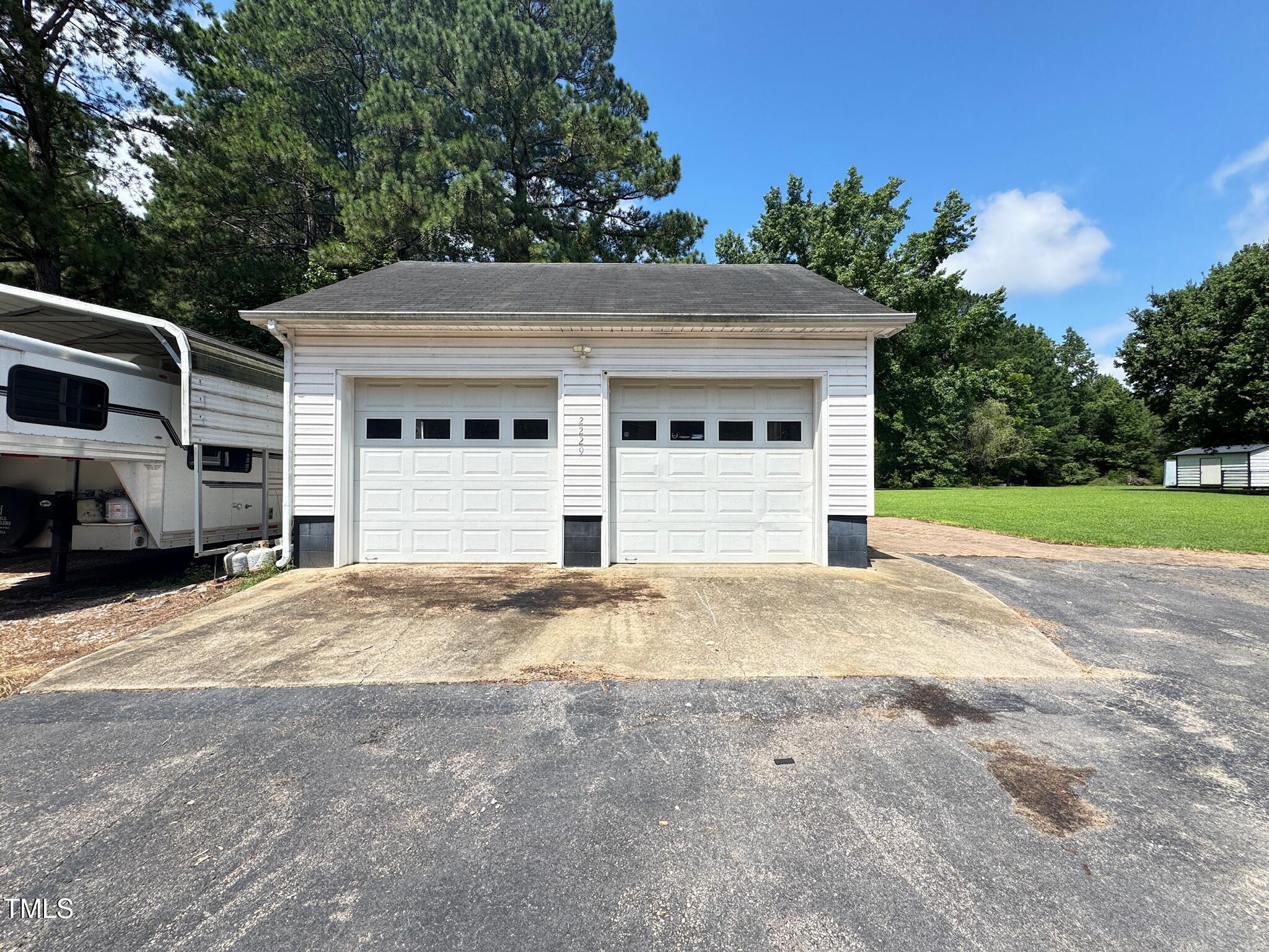 2229 Lizard Lick Road Zebulon, NC 27597 - Photo 6 of 57 a front view of a house with a yard and garage