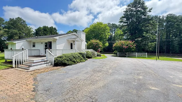 a view of a house with backyard and a tree