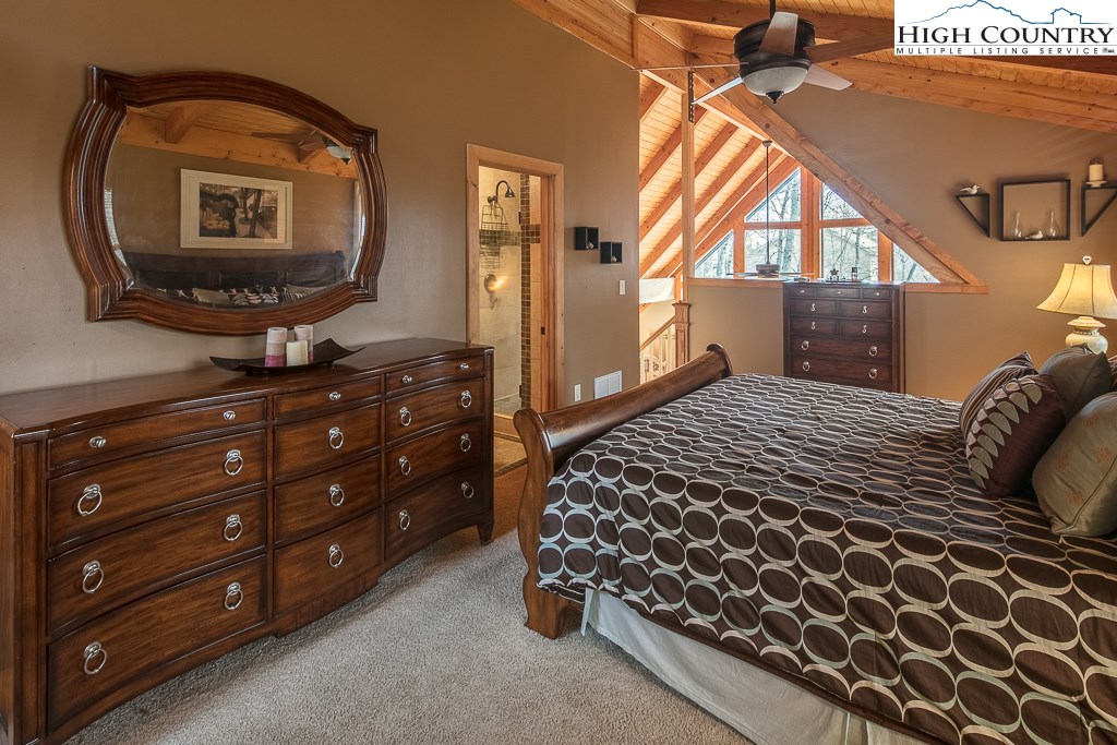 272 Locust Road Newland, NC 28657 - Photo 16 of 46 a bedroom with a bed a mirror on dresser and a window