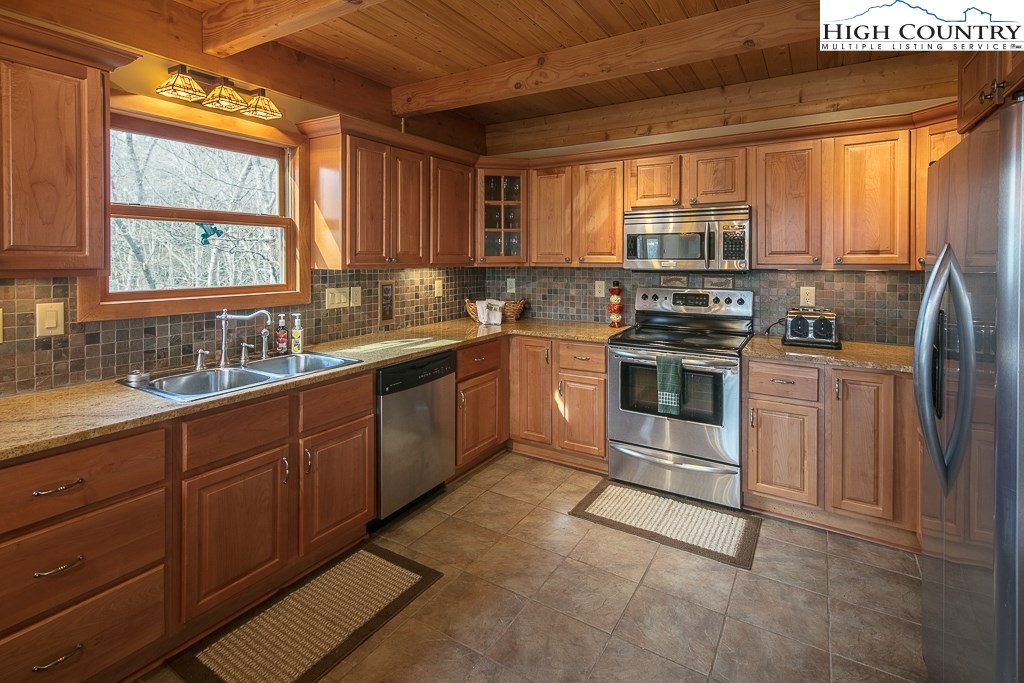 272 Locust Road Newland, NC 28657 - Photo 24 of 46 a kitchen with stainless steel appliances granite countertop a stove a sink dishwasher a microwave oven and a refrigerator with wooden cabinets