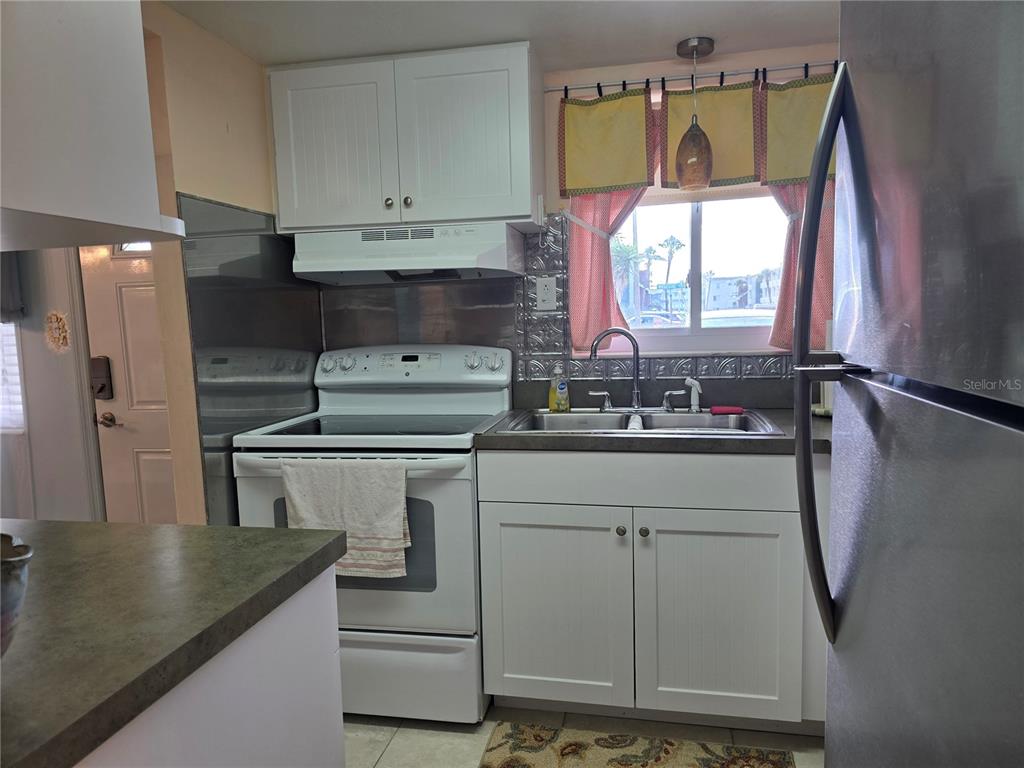 5850 Welcome Road, Unit J6 Bradenton, FL 34207 - Photo 11 of 30 a kitchen with a refrigerator and a sink