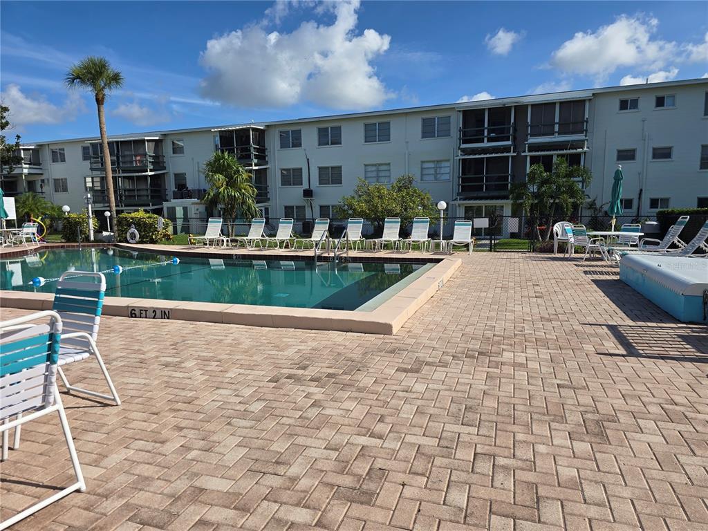 5850 Welcome Road, Unit J6 Bradenton, FL 34207 - Photo 25 of 30 a view of a patio with table and chairs potted plants and large tree
