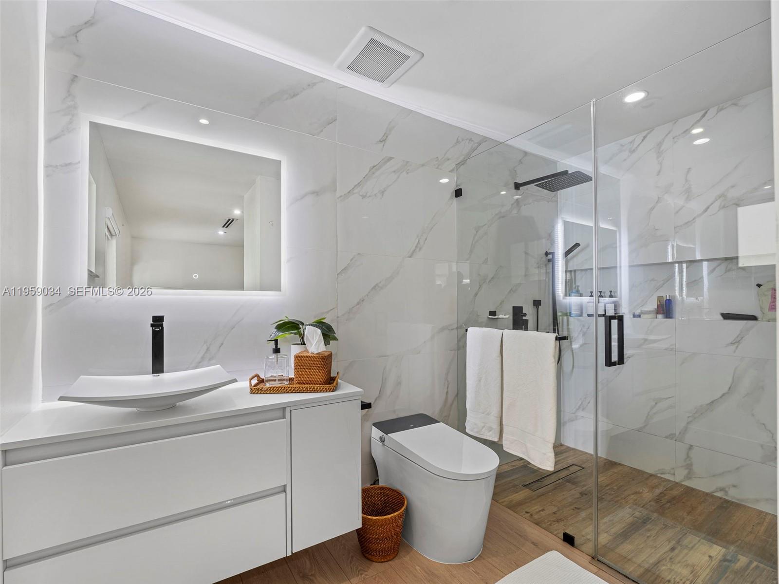 7753 Northwest 189th Street, Unit 1 Hialeah, FL 33015 - Photo 11 of 30 a bathroom with a sink toilet vanity and mirror
