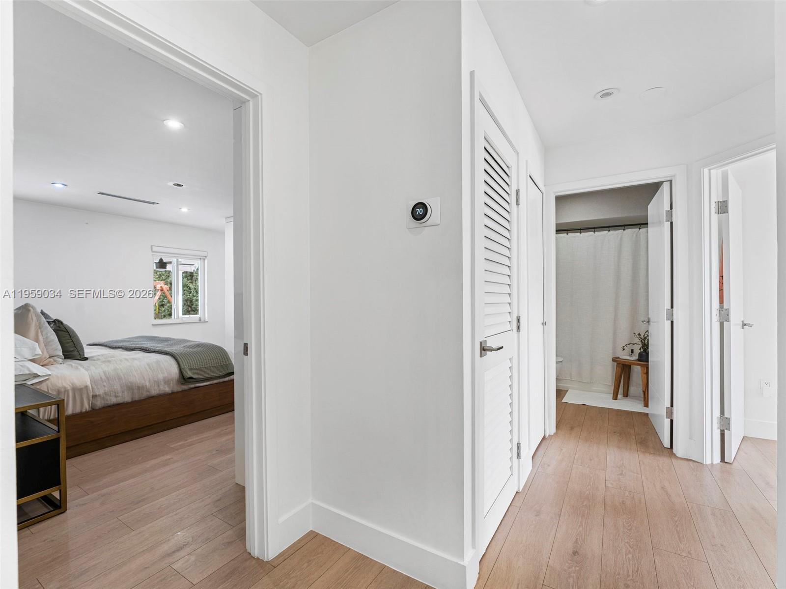 7753 Northwest 189th Street, Unit 1 Hialeah, FL 33015 - Photo 7 of 30 a hallway with a bed and wooden floor