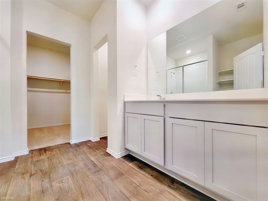 419 Sickle Loop Kyle, TX 78640 - Photo 17 of 35 A well-appointed bathroom vanity with ample storage and a clear view to an adjacent closet space.