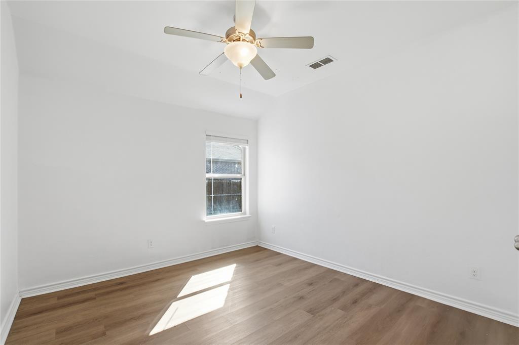 339 Blanco Drive Forney, TX 75126 - Photo 11 of 24 Spare room featuring wood finished floors, vaulted ceiling, and ceiling fan