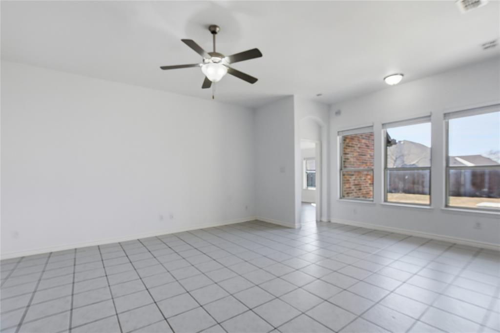 339 Blanco Drive Forney, TX 75126 - Photo 12 of 24 Empty room with arched walkways, ceiling fan, and light tile patterned floors