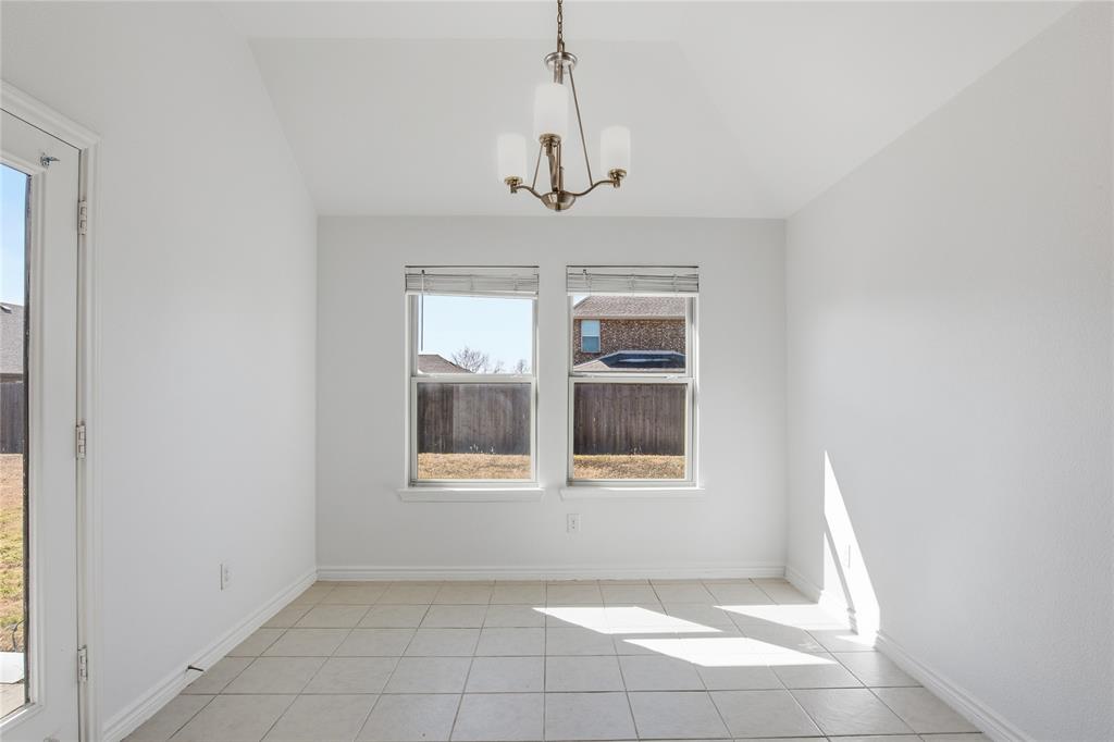 339 Blanco Drive Forney, TX 75126 - Photo 15 of 24 Unfurnished dining area with hanging lights, vaulted ceiling, and light tile patterned flooring