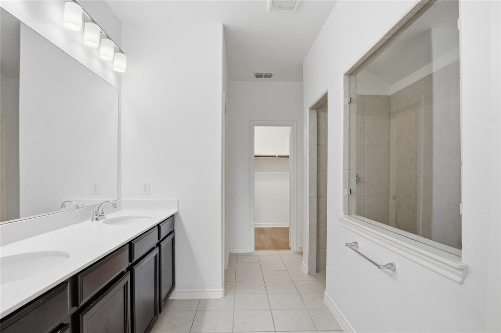 339 Blanco Drive Forney, TX 75126 - Photo 18 of 24 Bathroom with a walk in closet, a walk in shower, double vanity, and light tile patterned floors