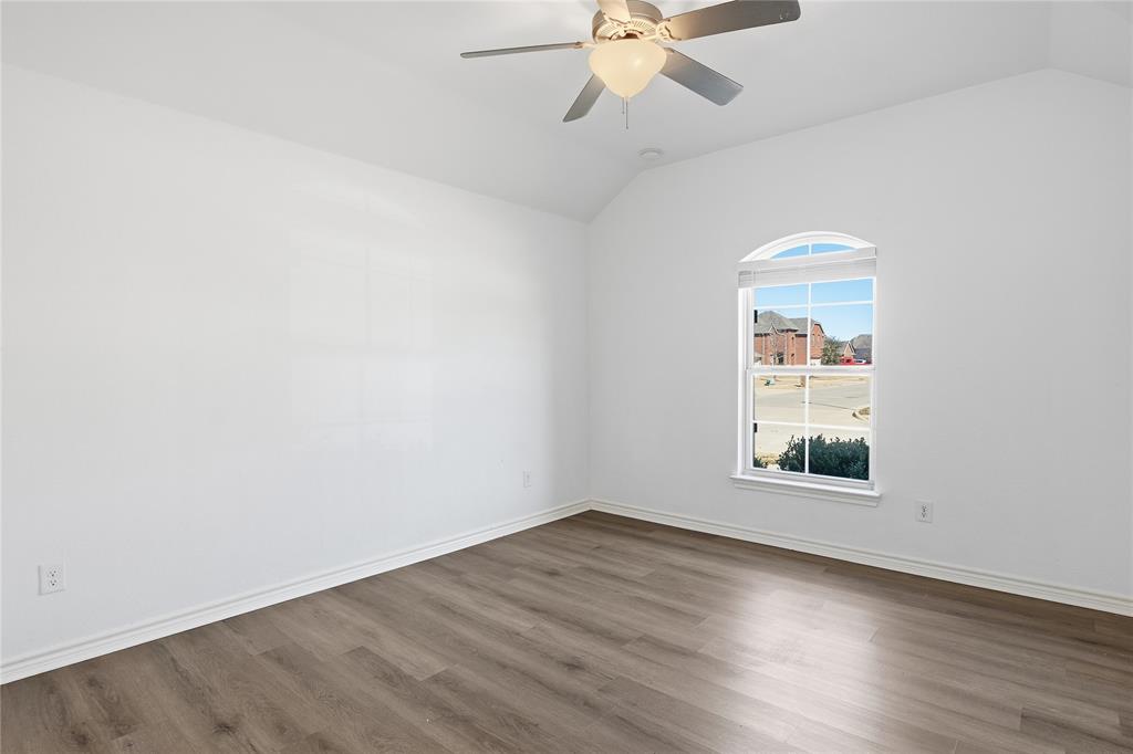 339 Blanco Drive Forney, TX 75126 - Photo 5 of 24 Empty room featuring vaulted ceiling, wood finished floors, and ceiling fan